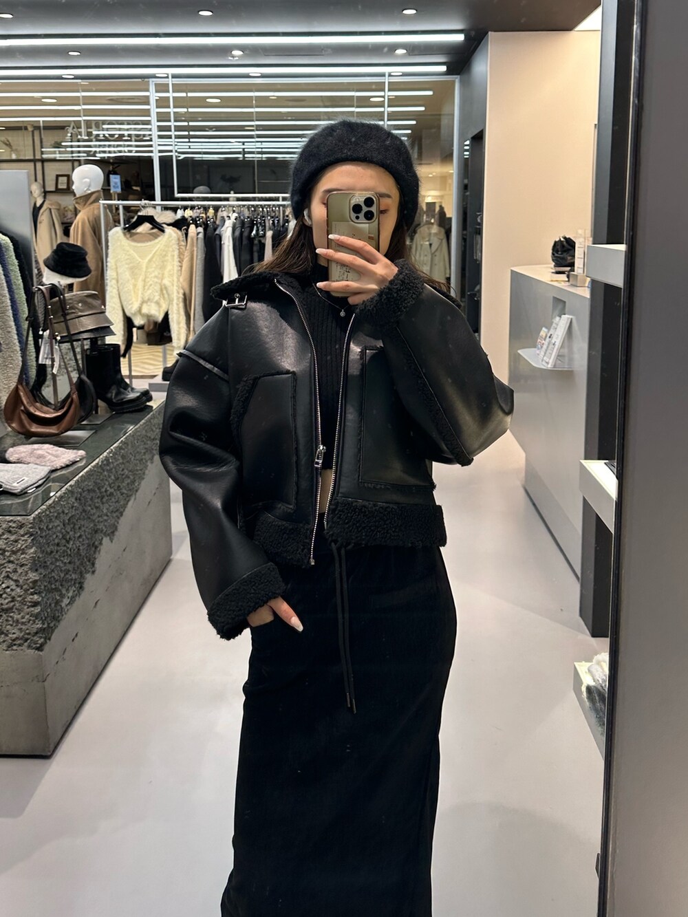 ブラック系のブルゾン、ブラック系のニット/セーター、ブラック系のブーツを着用したレディースの冬コーディネートの4枚目の写真