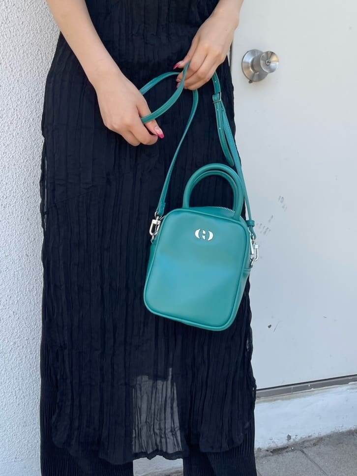 ブラック系のキャミソール、ブルー系のショルダーバッグ、ブラック系のその他パンツを着用したレディースの春コーディネートの6枚目の写真