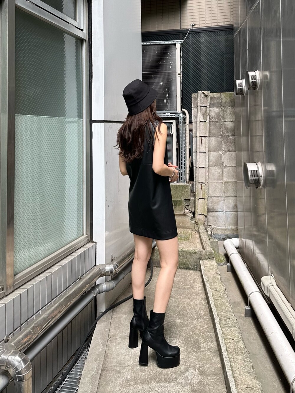 ブラック系のワンピース、ブラック系のブーツ、その他のタンクトップを着用したレディースの夏コーディネートの2枚目の写真