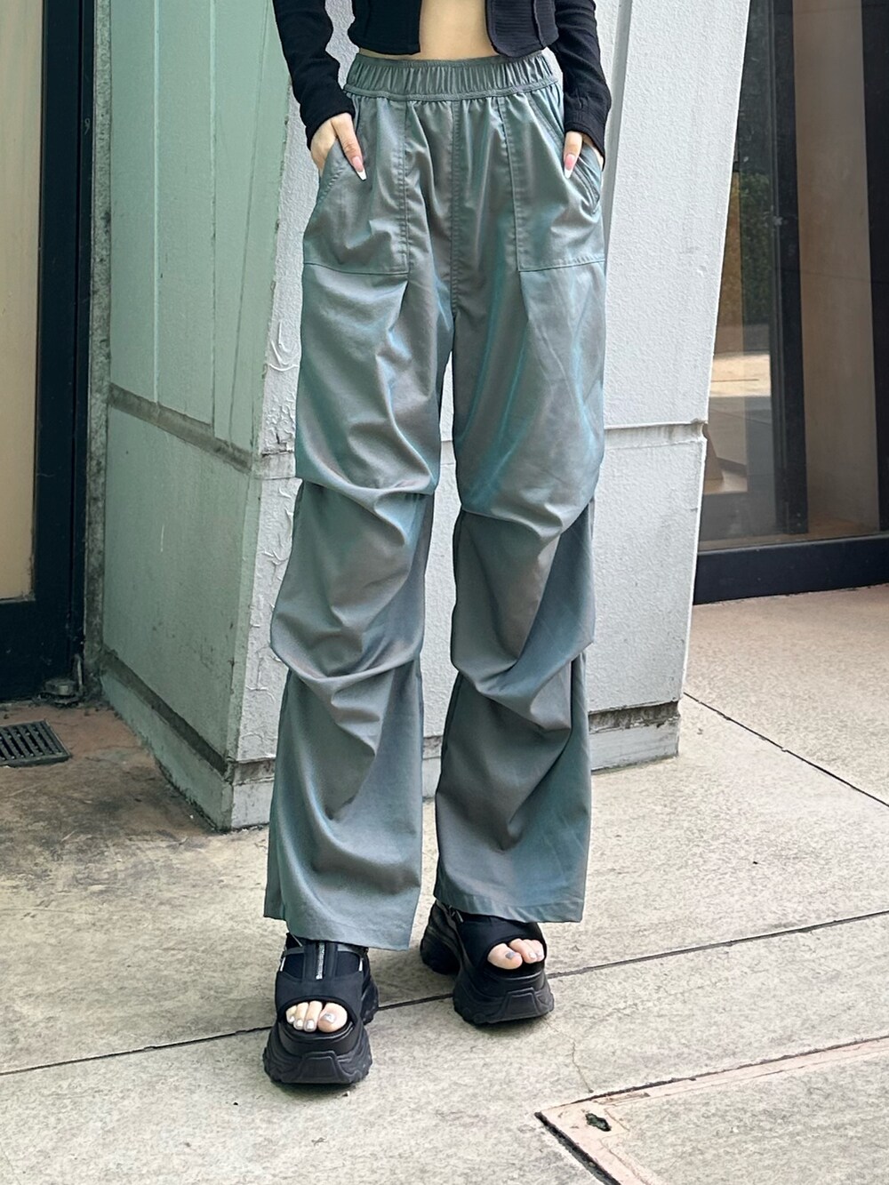 グリーン系のその他パンツ、ブラック系のTシャツ/カットソー、ブラック系のサンダルを着用したレディースの春コーディネートの7枚目の写真