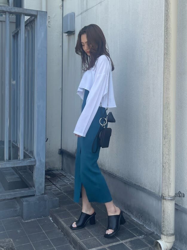 ブラック系のハンドバッグ、ホワイト系のTシャツ/カットソー、ブラック系のサンダルを着用したレディースの春コーディネートの2枚目の写真