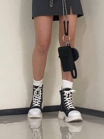 イエロー系のタンクトップ、ブラック系のスニーカー、ブラック系のハンドバッグを着用したレディースの春コーディネートの7枚目の写真