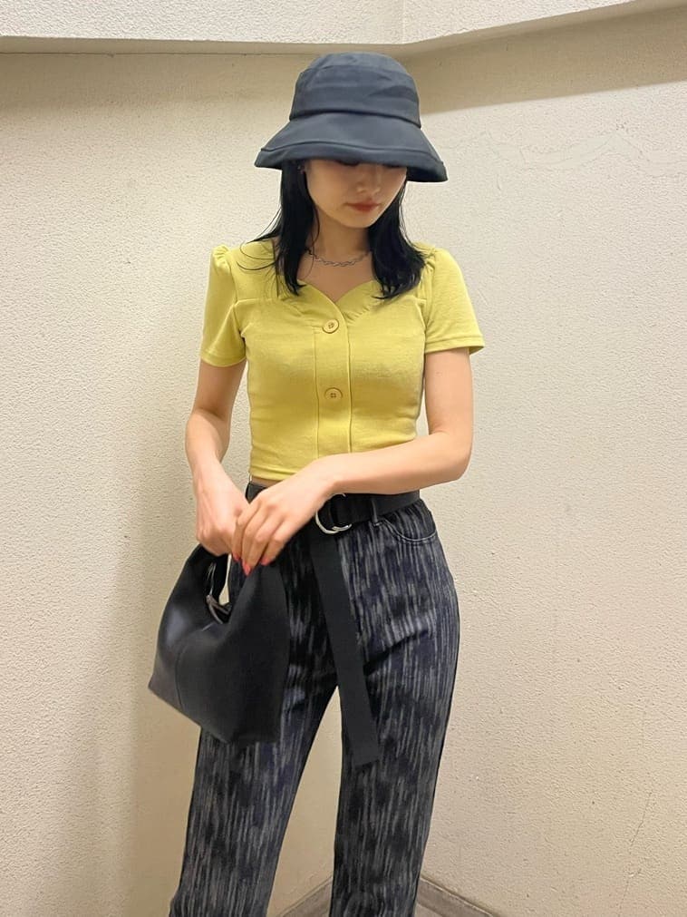 ブラック系のデニムパンツ、イエロー系のTシャツ/カットソー、ブラック系のサンダルを着用したレディースの夏コーディネートの4枚目の写真