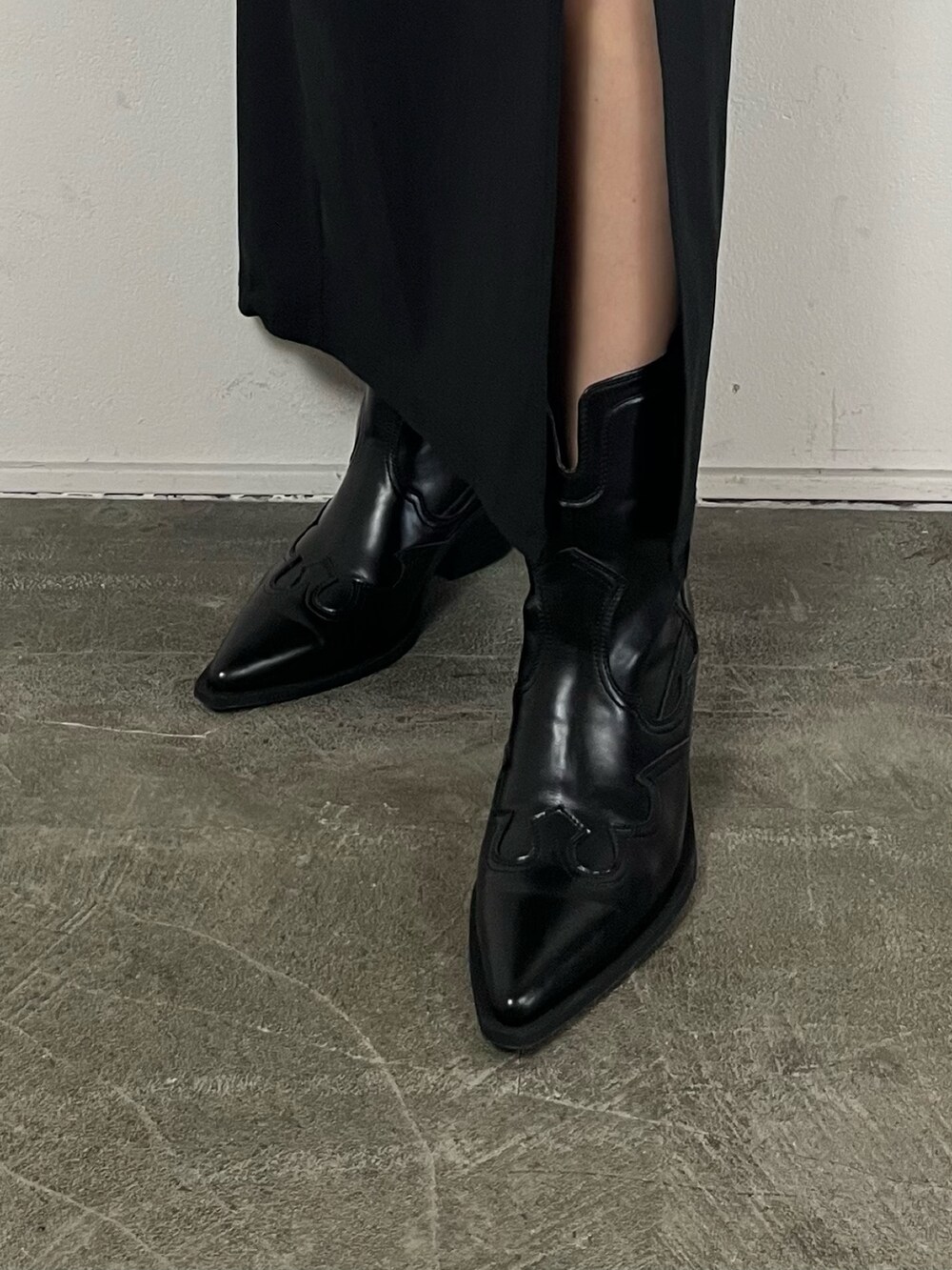 ブラック系のスカート、グリーン系のキャミソール、ブラック系のブーツを着用したレディースの春コーディネートの7枚目の写真