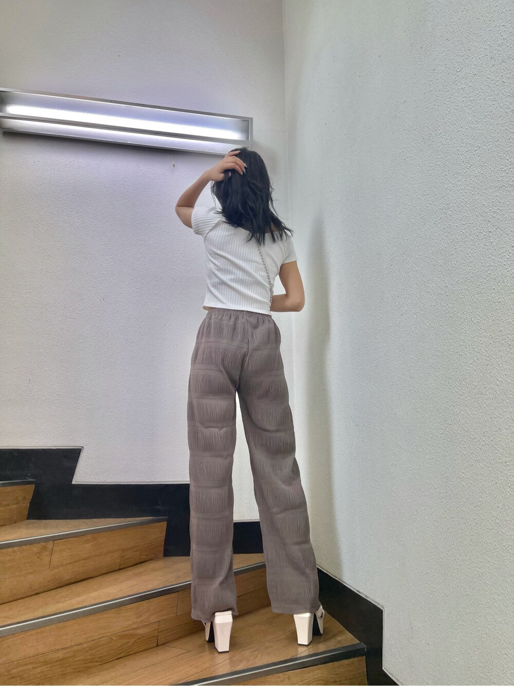 グレー系のその他パンツ、ブラウン系のショルダーバッグ、ホワイト系のTシャツ/カットソーを着用したレディースの春コーディネートの3枚目の写真