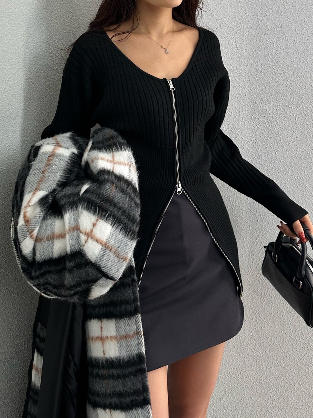 グレー系のスカート、ブラック系のニット/セーター、その他のチェスターコートを着用したレディースの冬コーディネートの5枚目の写真