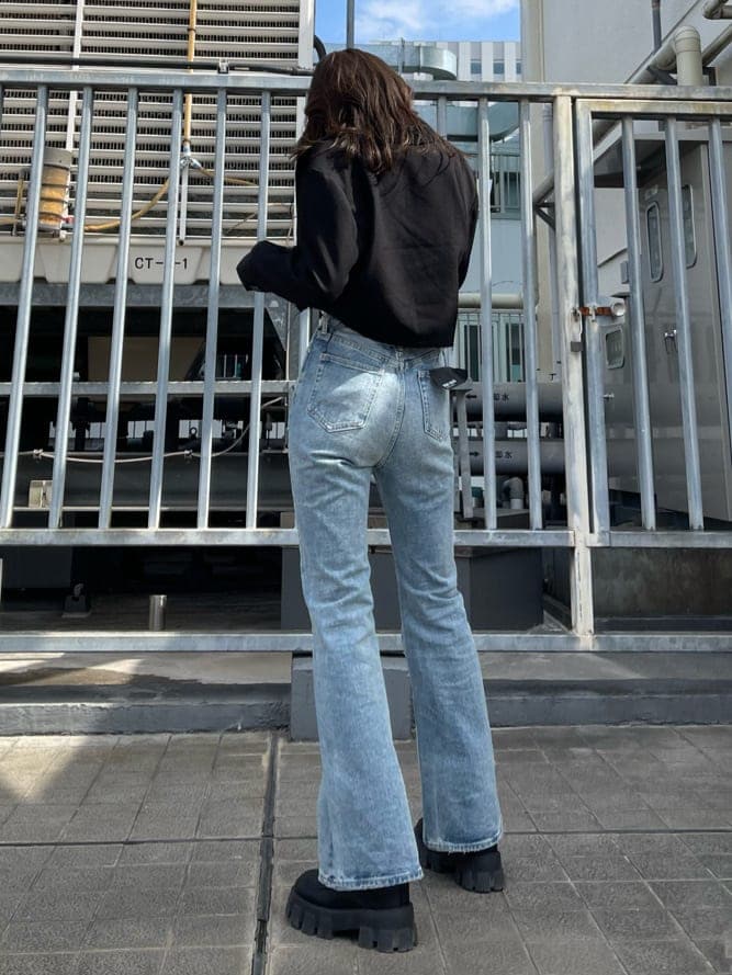 ブラック系のテーラードジャケット、ブルー系のデニムパンツ、ブラック系のブーツを着用したレディースの春コーディネートの7枚目の写真