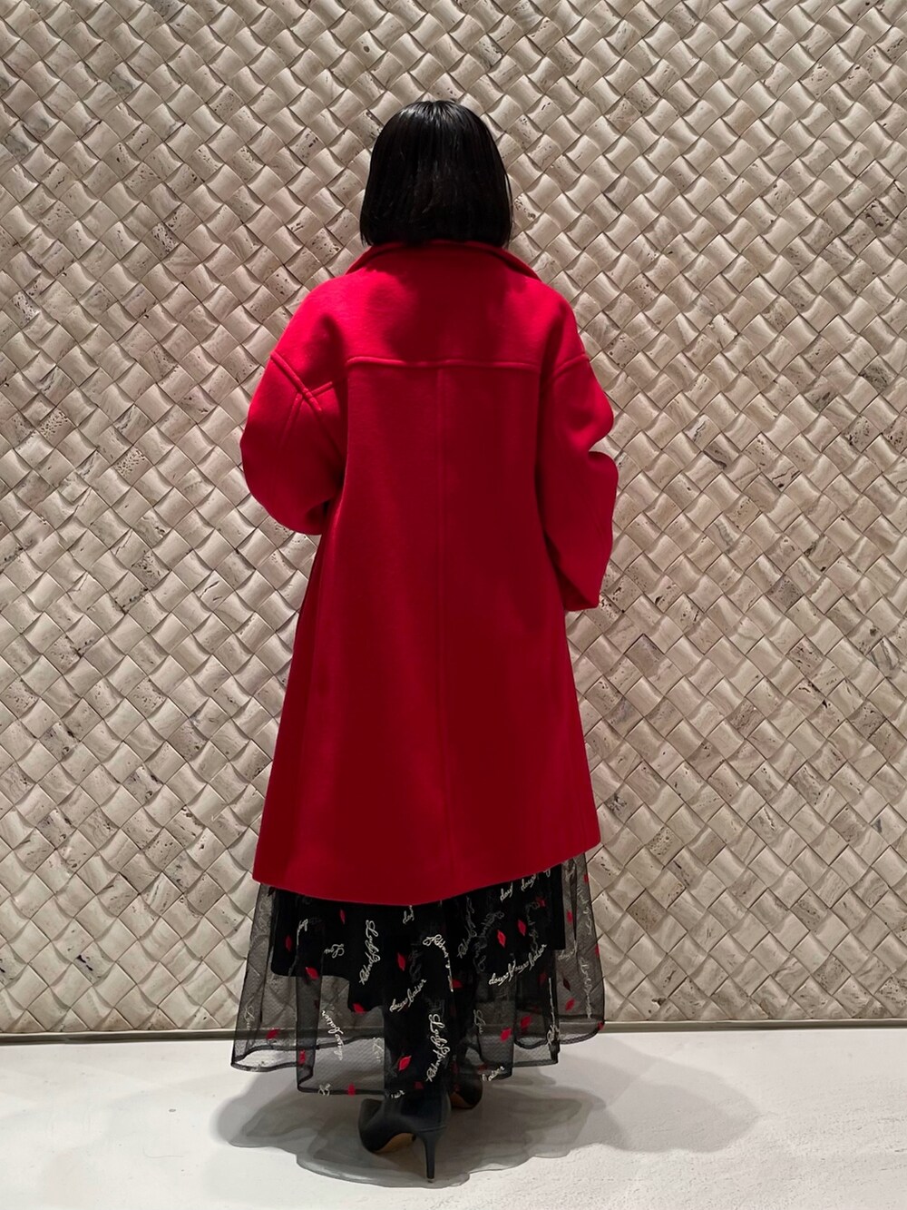 レッド系のその他アウター、ブラック系のスカート、ブラック系のカーディガン/ボレロを着用したレディースの冬コーディネートの4枚目の写真