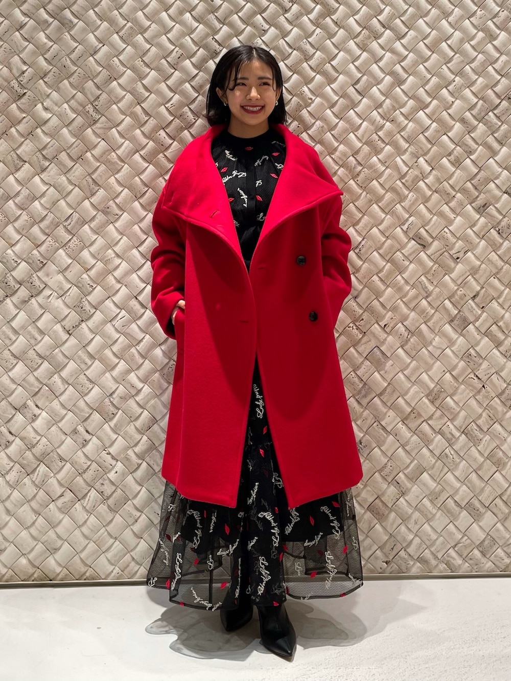 レッド系のその他アウター、ブラック系のスカート、ブラック系のカーディガン/ボレロを着用したレディースの冬コーディネートの3枚目の写真