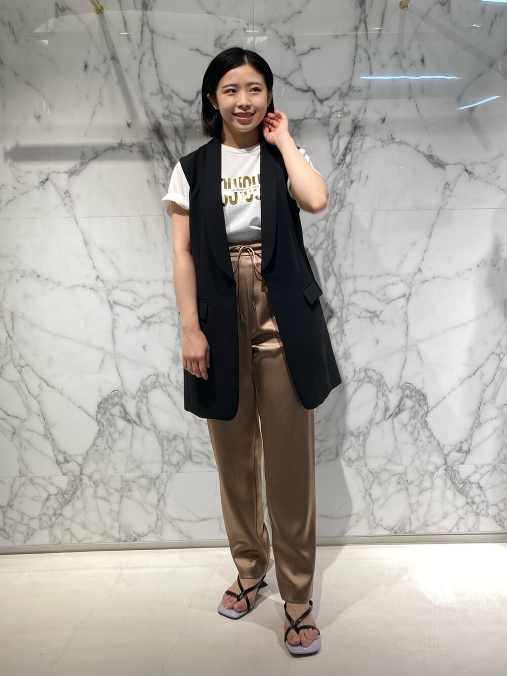 ベージュ系のその他パンツ、ブラック系のベスト、ホワイト系のTシャツ/カットソーを着用したレディースの夏コーディネートの2枚目の写真