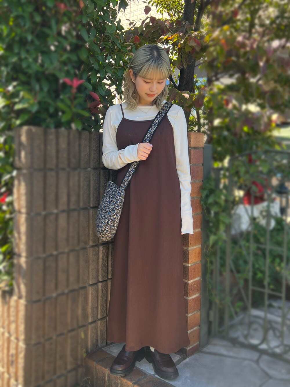 ブラウン系のワンピース/ドレス、ホワイト系のTシャツ/カットソー、ブラウン系のローファーを着用したレディースの秋コーディネートの2枚目の写真