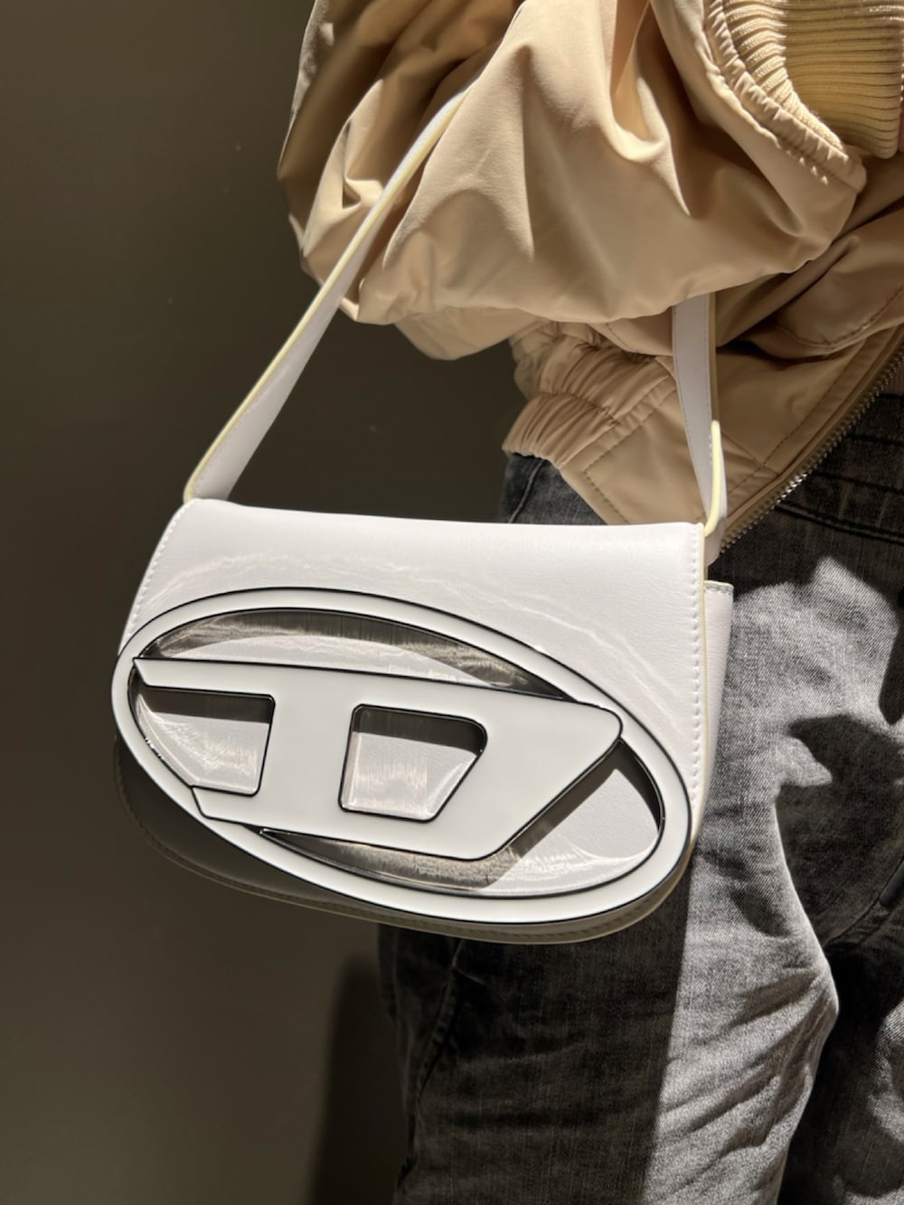 ホワイト系のTシャツ/カットソー、ホワイト系のブルゾン、ホワイト系のショルダーバッグを着用したレディースの春コーディネートの2枚目の写真