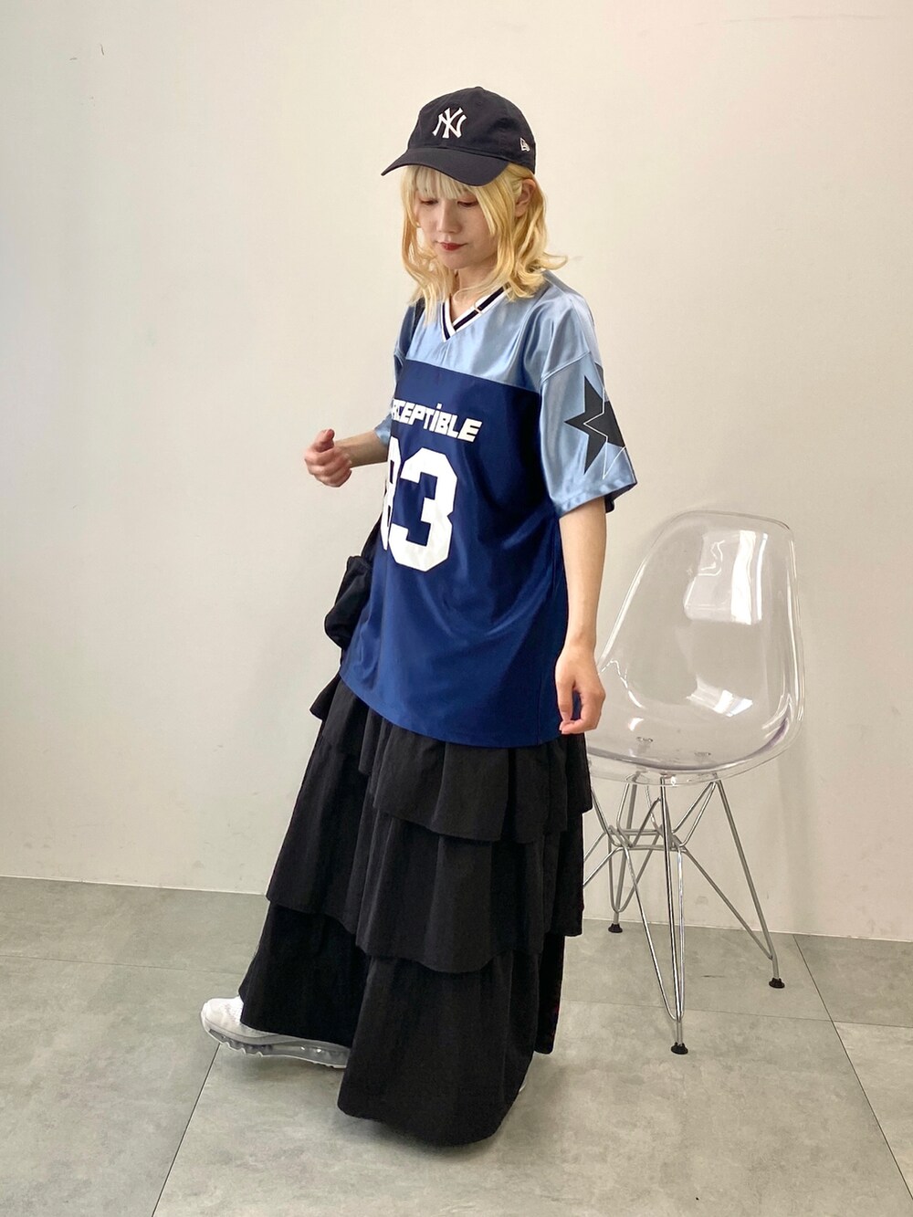 ブラック系のスカート、ブルー系のTシャツ/カットソー、ブラック系のショルダーバッグを着用したレディースの夏コーディネートの3枚目の写真
