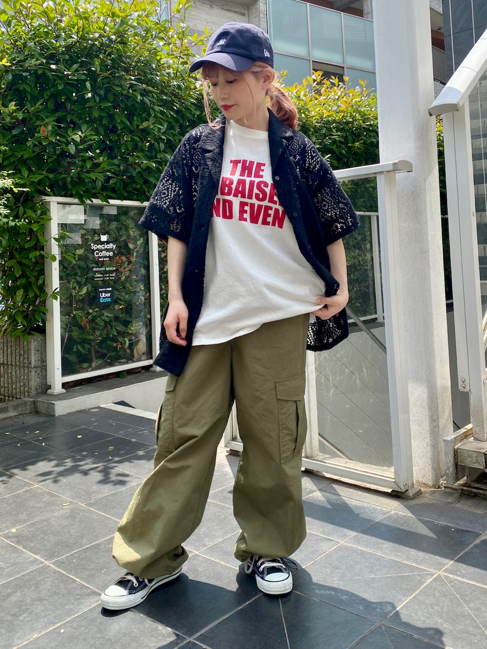 ホワイト系のTシャツ/カットソー、ブラック系のシャツ/ブラウス、グリーン系のカーゴパンツを着用したレディースの春コーディネートの2枚目の写真