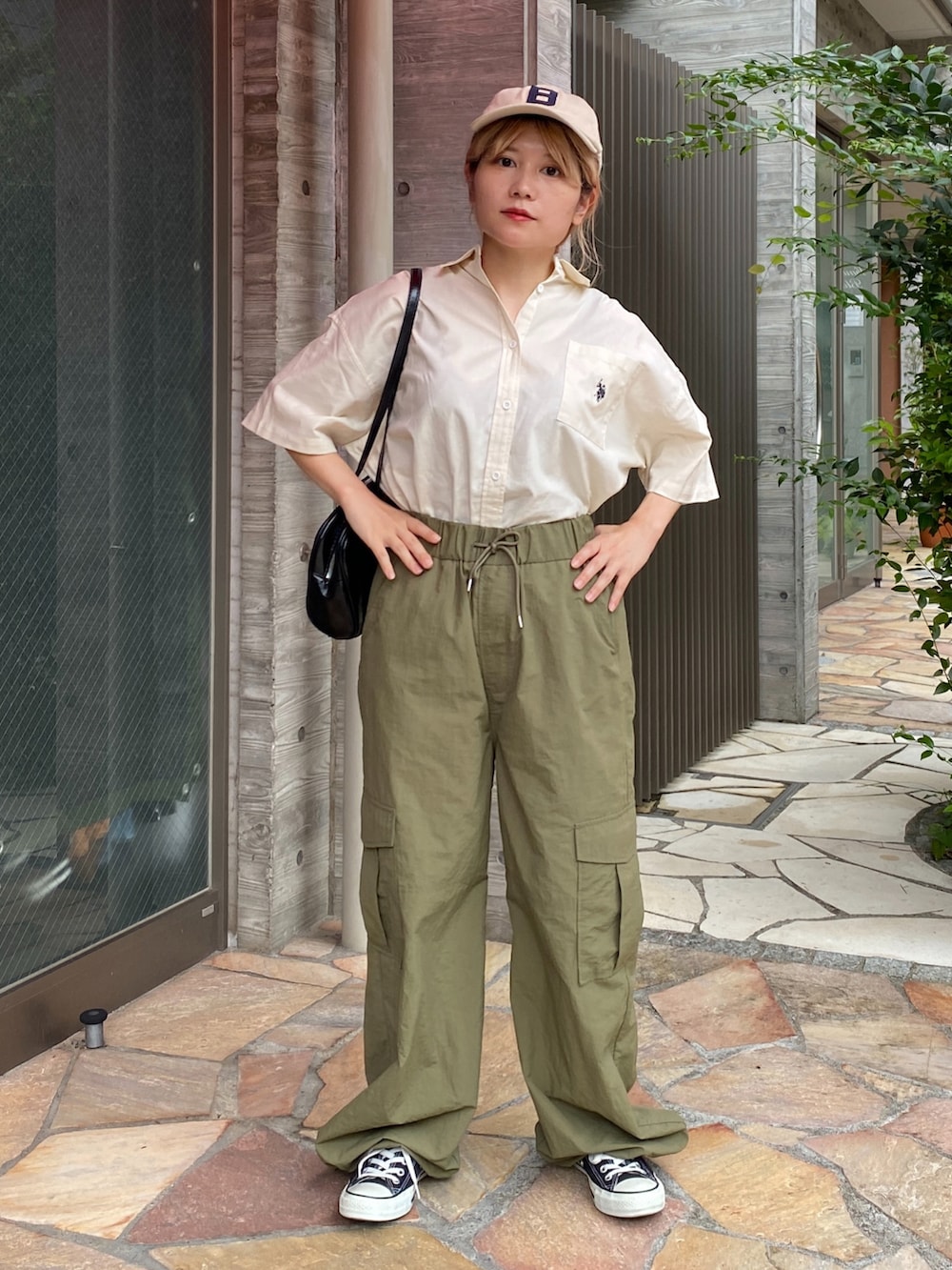 ホワイト系のシャツ/ブラウス、グリーン系のカーゴパンツ、ブラック系のスニーカーを着用したレディースの夏コーディネートの2枚目の写真