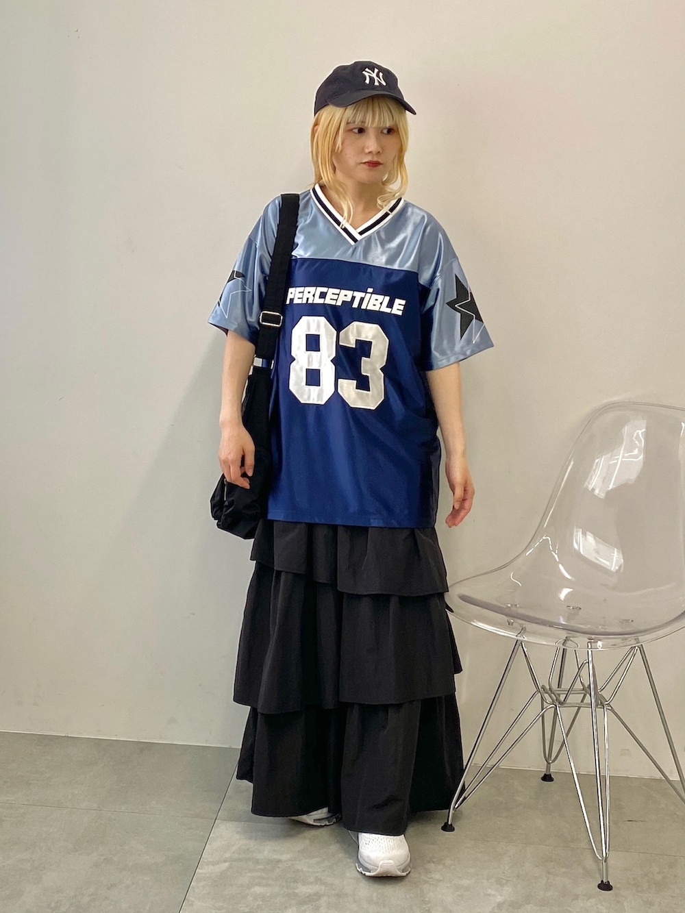 ブラック系のスカート、ブルー系のTシャツ/カットソー、ブラック系のショルダーバッグを着用したレディースの夏コーディネートの2枚目の写真