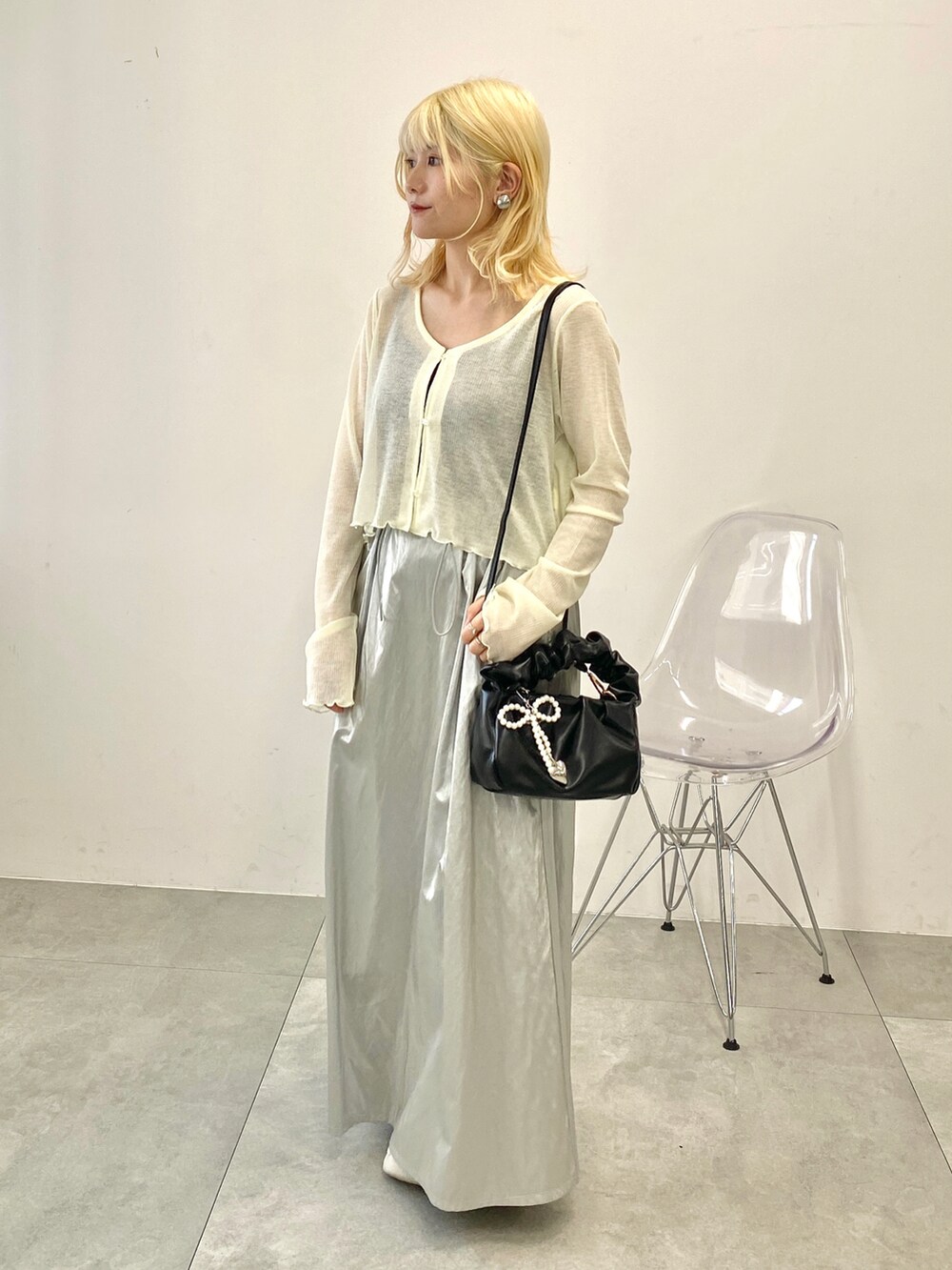 ホワイト系のカーディガン/ボレロ、シルバー系のスカート、ホワイト系のスニーカーを着用したレディースの夏コーディネートの2枚目の写真