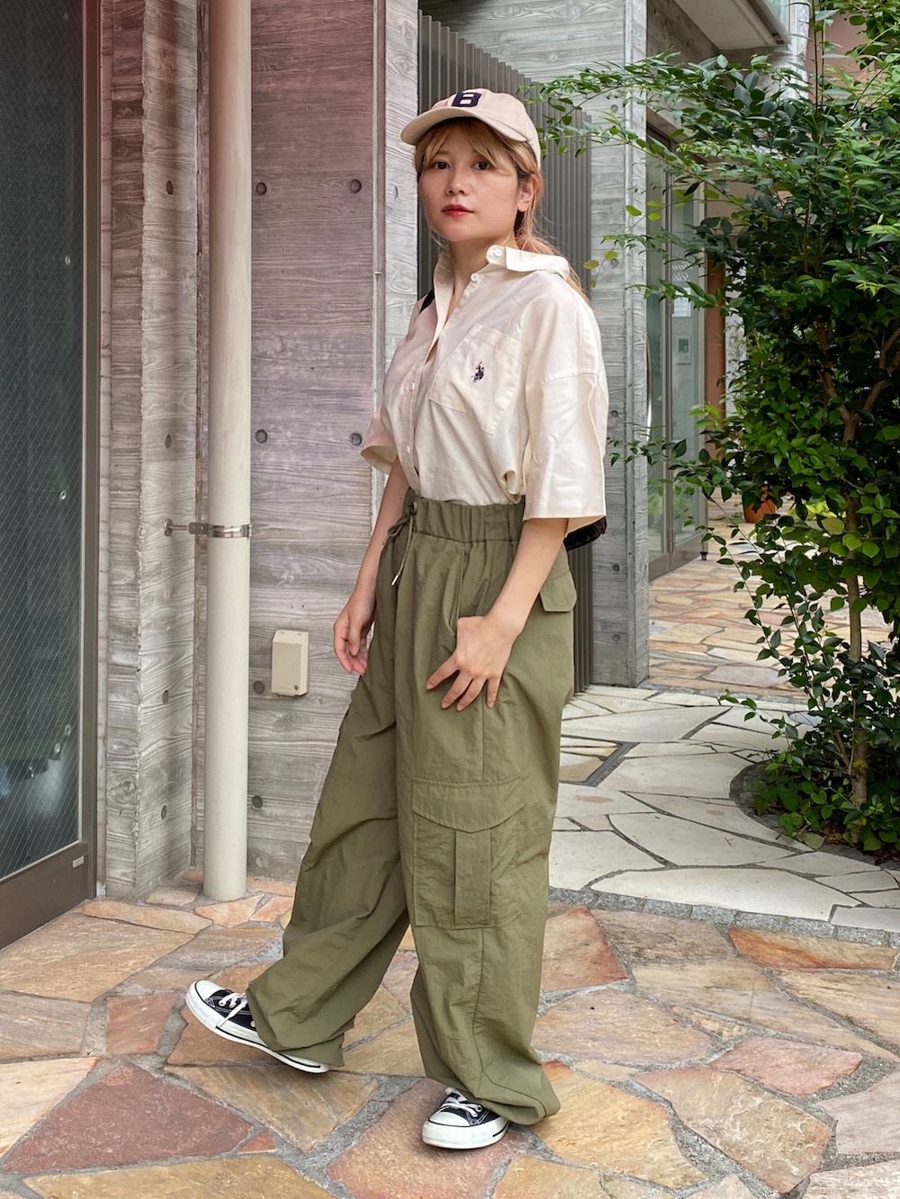 ホワイト系のシャツ/ブラウス、グリーン系のカーゴパンツ、ブラック系のスニーカーを着用したレディースの夏コーディネートの4枚目の写真