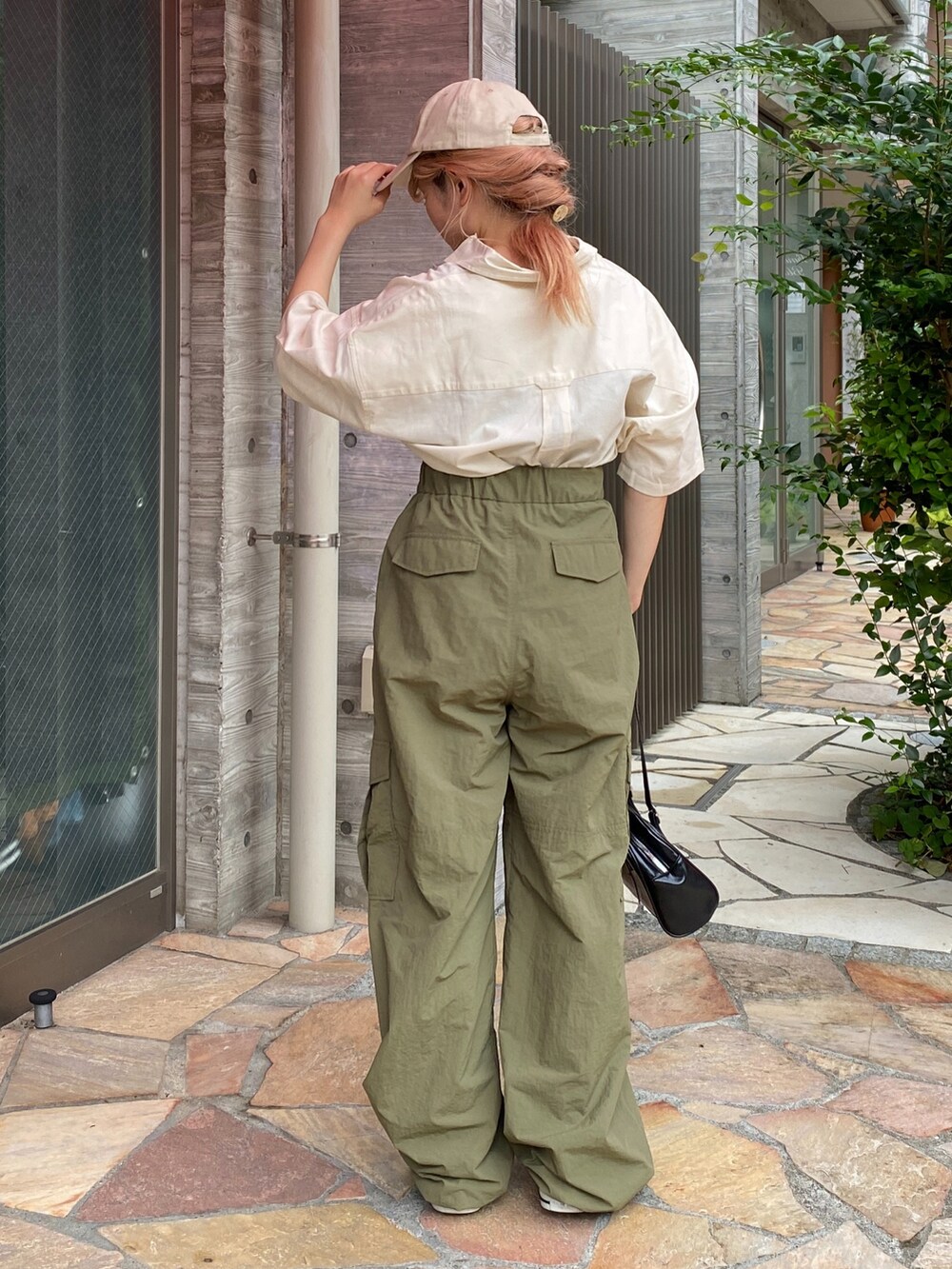 ホワイト系のシャツ/ブラウス、グリーン系のカーゴパンツ、ブラック系のスニーカーを着用したレディースの夏コーディネートの3枚目の写真