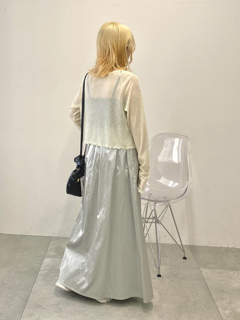 ホワイト系のカーディガン/ボレロ、シルバー系のスカート、ホワイト系のスニーカーを着用したレディースの夏コーディネートの3枚目の写真