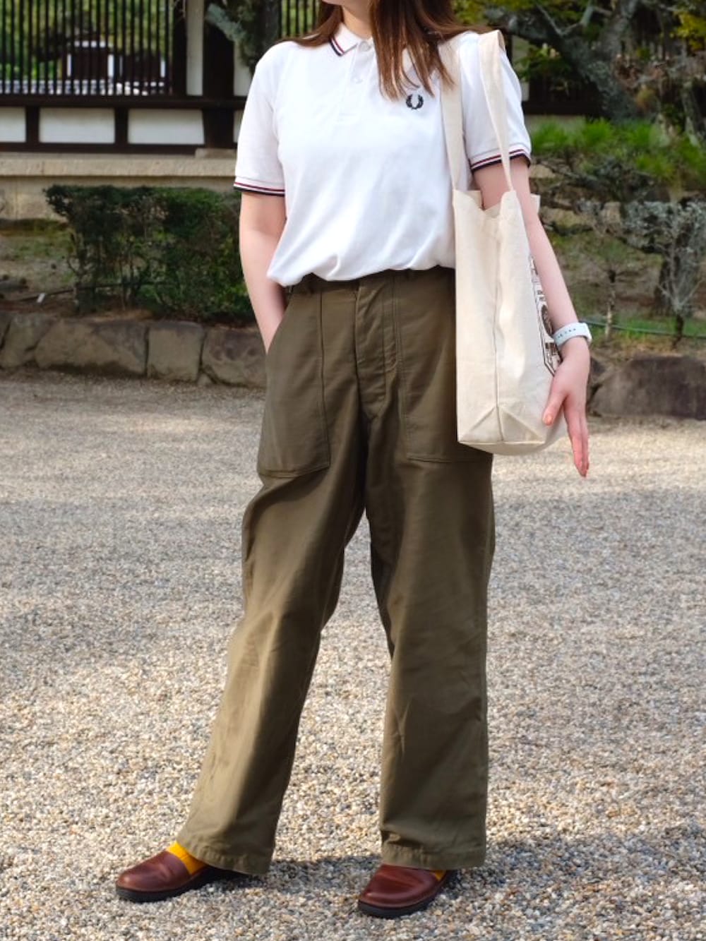 ホワイト系のポロシャツ、グリーン系のその他パンツ、ブラウン系のサンダルを着用したレディースの秋コーディネートの2枚目の写真