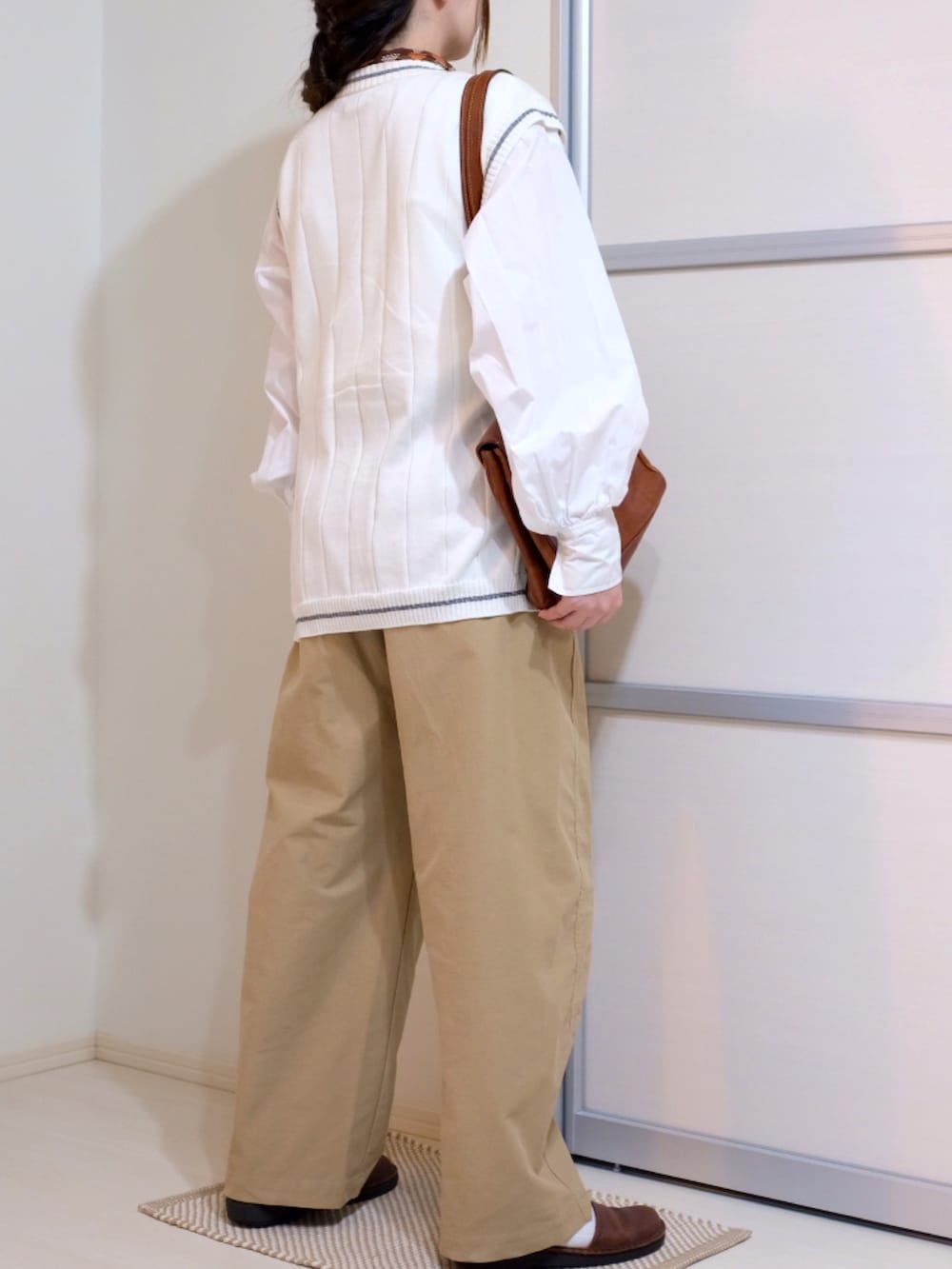 ホワイト系のシャツ/ブラウス、ホワイト系のベスト、ベージュ系のパンツを着用したレディースの秋コーディネートの2枚目の写真