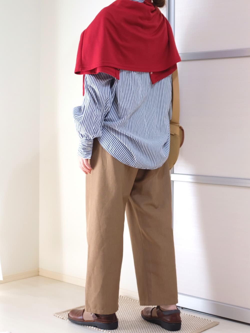 レッド系のカーディガン/ボレロ、ブルー系のシャツ/ブラウス、ベージュ系のショルダーバッグを着用したレディースの秋コーディネートの3枚目の写真