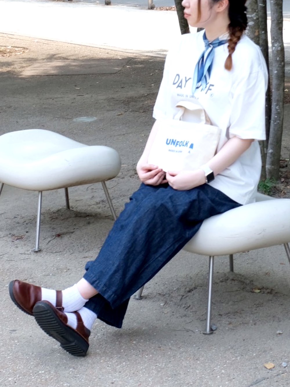 ホワイト系のTシャツ/カットソー、ブルー系のデニムパンツ、ブラウン系のサンダルを着用したレディースの秋コーディネートの2枚目の写真