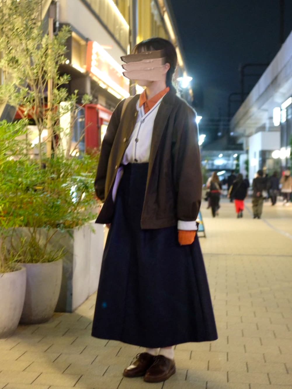 ベージュ系のショルダーバッグ、オレンジ系のシャツ/ブラウス、ホワイト系のベストを着用したレディースの秋コーディネートの3枚目の写真