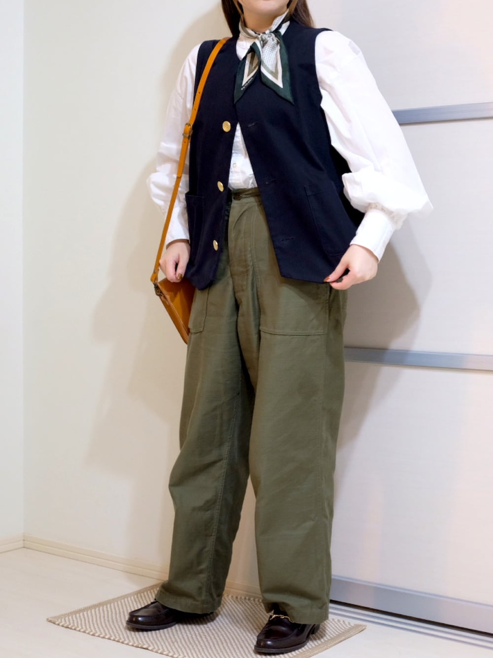 ホワイト系のシャツ/ブラウス、ブラック系のベスト、グリーン系のその他パンツを着用したレディースの秋コーディネートの3枚目の写真