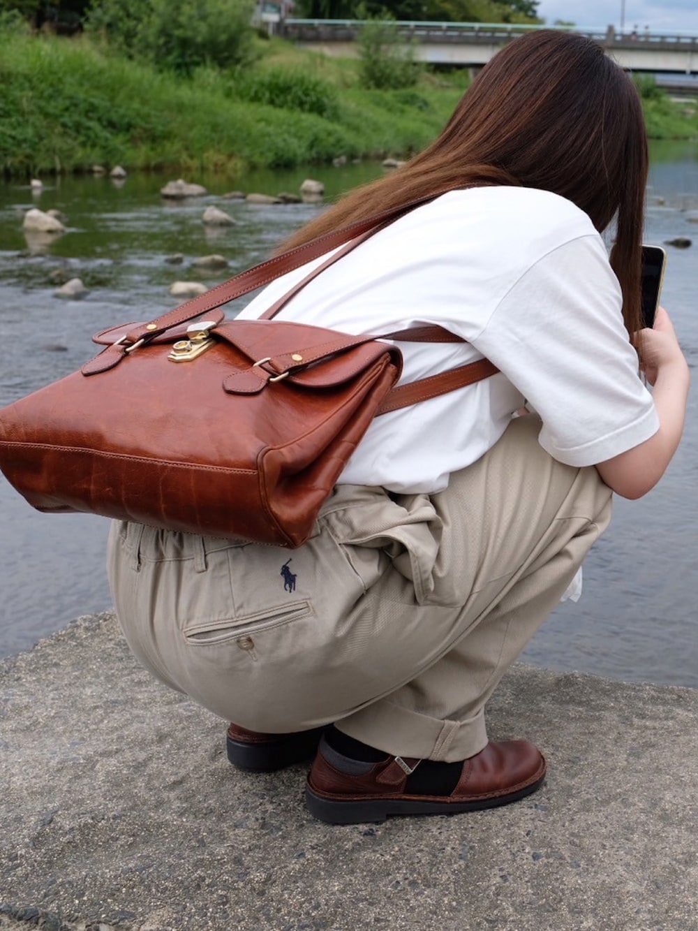 ホワイト系のTシャツ/カットソー、ベージュ系のパンツ、ブラウン系のサンダルを着用したレディースの秋コーディネートの2枚目の写真