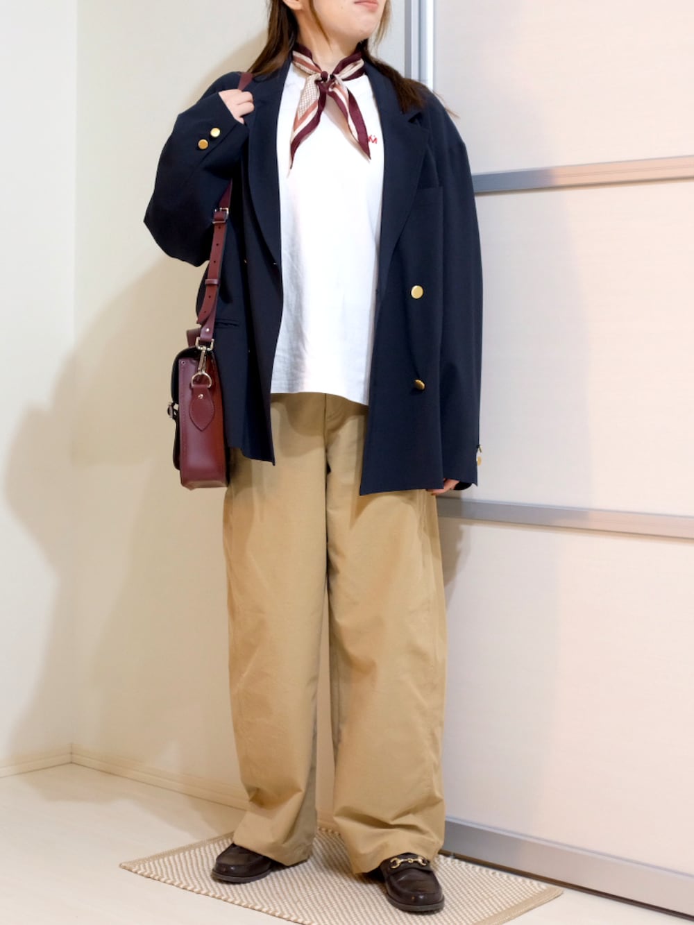 ホワイト系のTシャツ/カットソー、ブルー系のテーラードジャケット、ベージュ系のパンツを着用したレディースの秋コーディネートの3枚目の写真