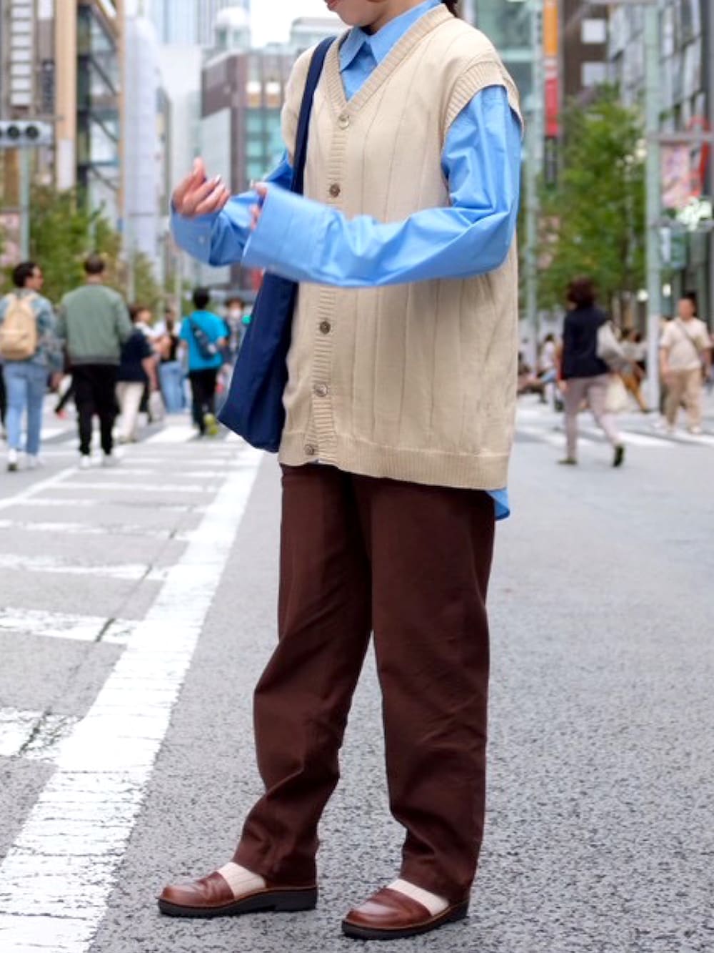 ブルー系のシャツ/ブラウス、ブルー系のバッグ、ベージュ系のベストを着用したレディースの秋コーディネートの3枚目の写真