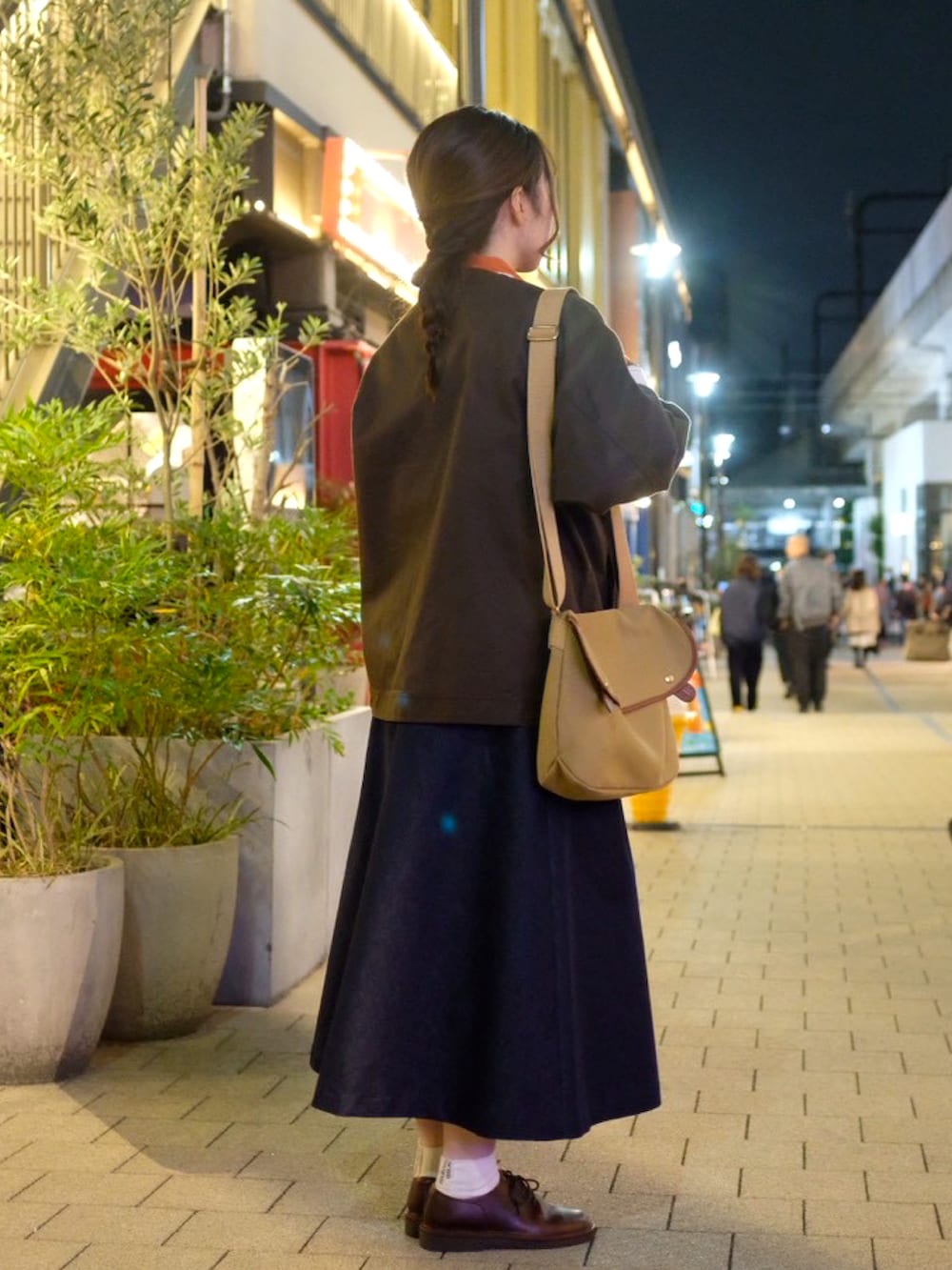 ベージュ系のショルダーバッグ、オレンジ系のシャツ/ブラウス、ホワイト系のベストを着用したレディースの秋コーディネートの2枚目の写真