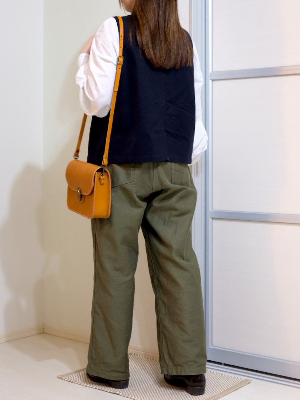 ホワイト系のシャツ/ブラウス、ブラック系のベスト、グリーン系のその他パンツを着用したレディースの秋コーディネートの2枚目の写真