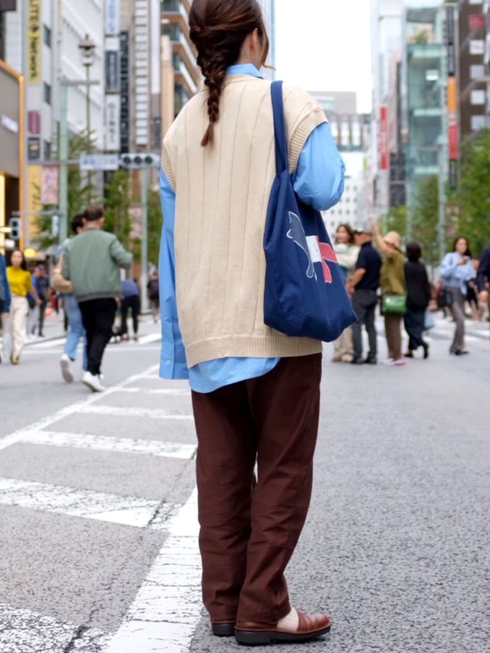 ブルー系のシャツ/ブラウス、ブルー系のバッグ、ベージュ系のベストを着用したレディースの秋コーディネートの2枚目の写真