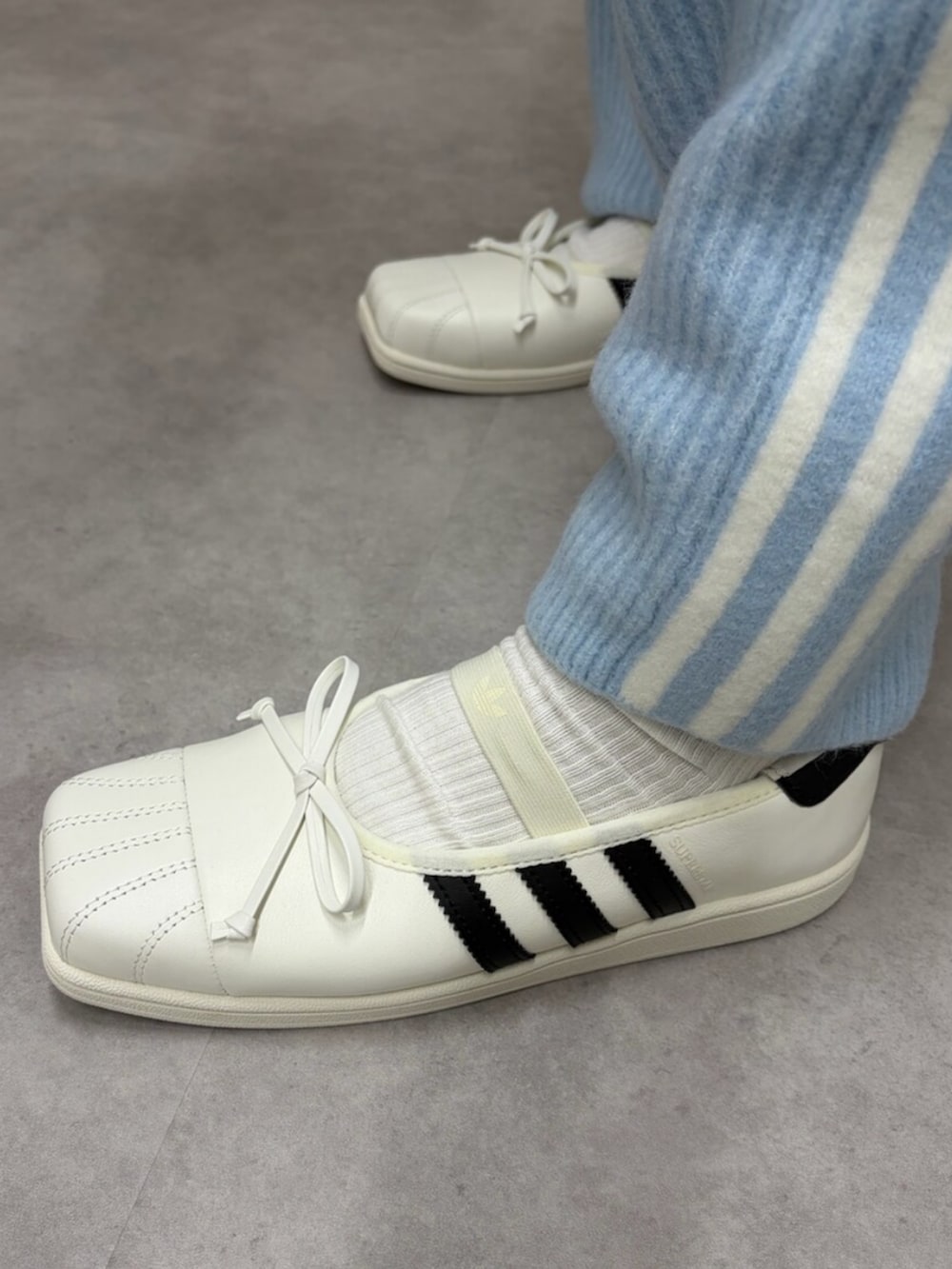ブルー系のトップス、ブルー系のその他パンツ、ホワイト系のハンドバッグを着用したレディースの秋コーディネートの4枚目の写真