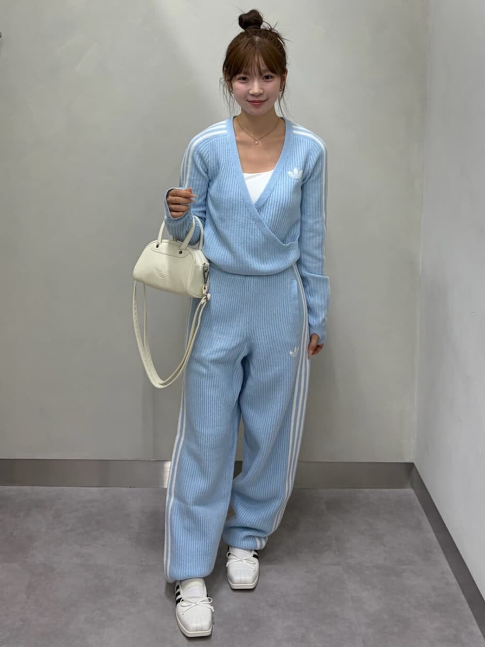 ブルー系のトップス、ブルー系のその他パンツ、ホワイト系のハンドバッグを着用したレディースの秋コーディネートの2枚目の写真