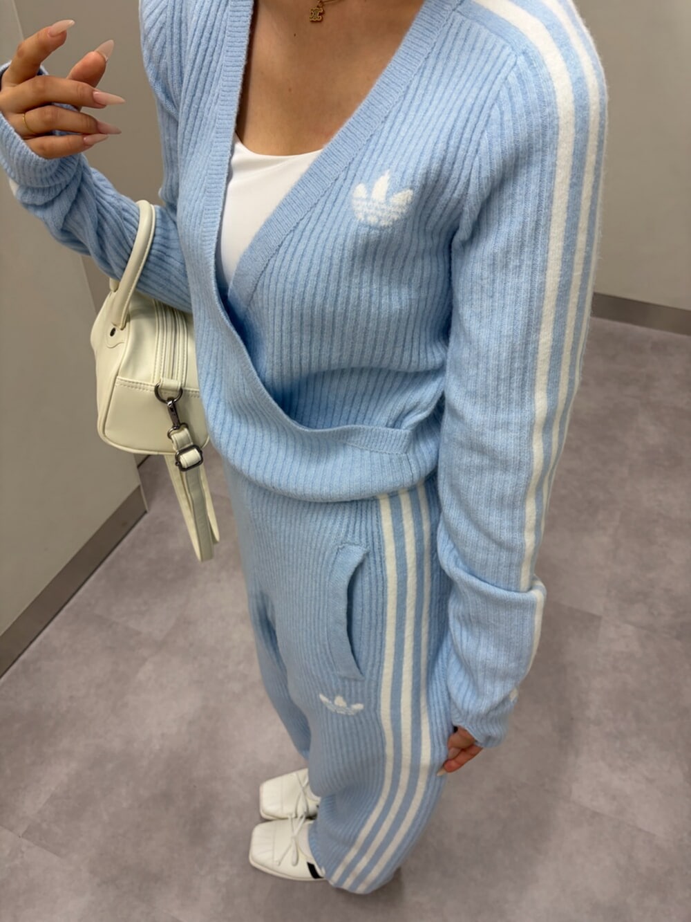 ブルー系のトップス、ブルー系のその他パンツ、ホワイト系のハンドバッグを着用したレディースの秋コーディネートの3枚目の写真