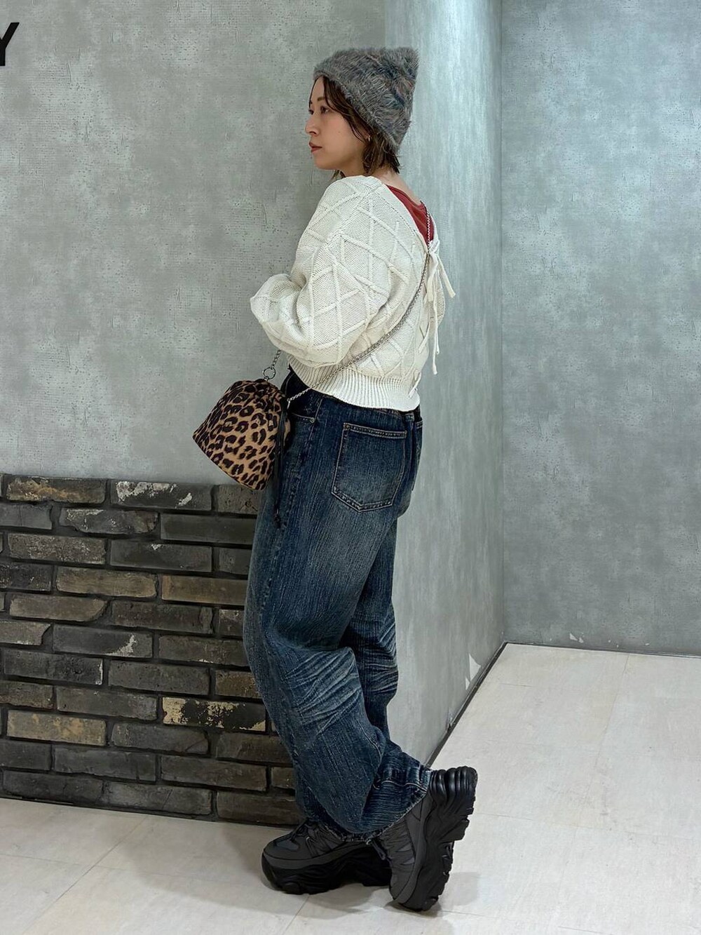 グレー系のスニーカー、ブルー系のデニムパンツ、ホワイト系のニット/セーターを着用したレディースの秋コーディネートの5枚目の写真