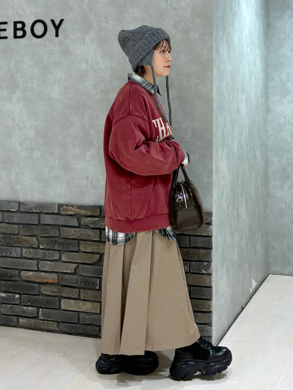 ブラック系のブーツ、レッド系のスウェット、ブルー系のシャツ/ブラウスを着用したレディースの秋コーディネートの4枚目の写真