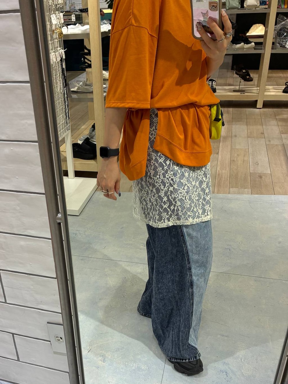 ブルー系のデニムパンツ、オレンジ系のTシャツ/カットソーを着用したレディースの春コーディネートの4枚目の写真