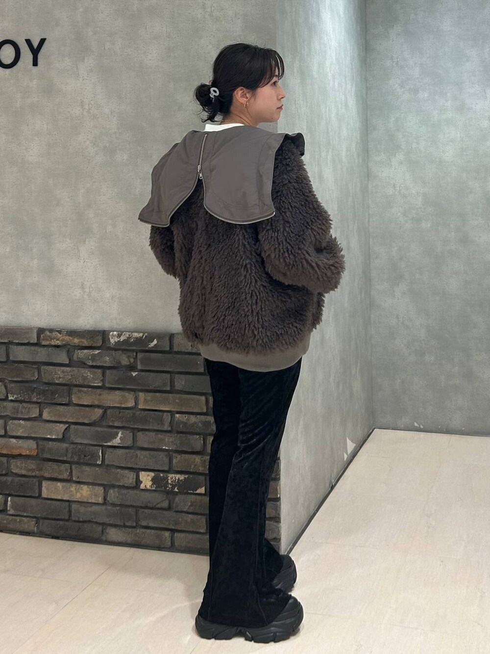 ブラック系のスニーカー、ブラウン系のブルゾン、ブラック系のその他パンツを着用したレディースの秋コーディネートの3枚目の写真