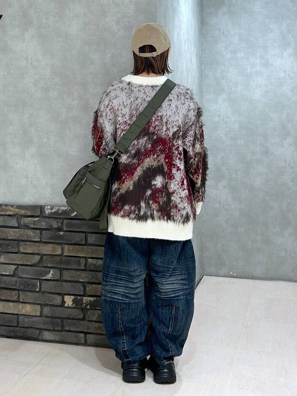 ブラック系のスニーカー、グリーン系のボストンバッグ、ホワイト系のカーディガン/ボレロを着用したレディースの秋コーディネートの4枚目の写真