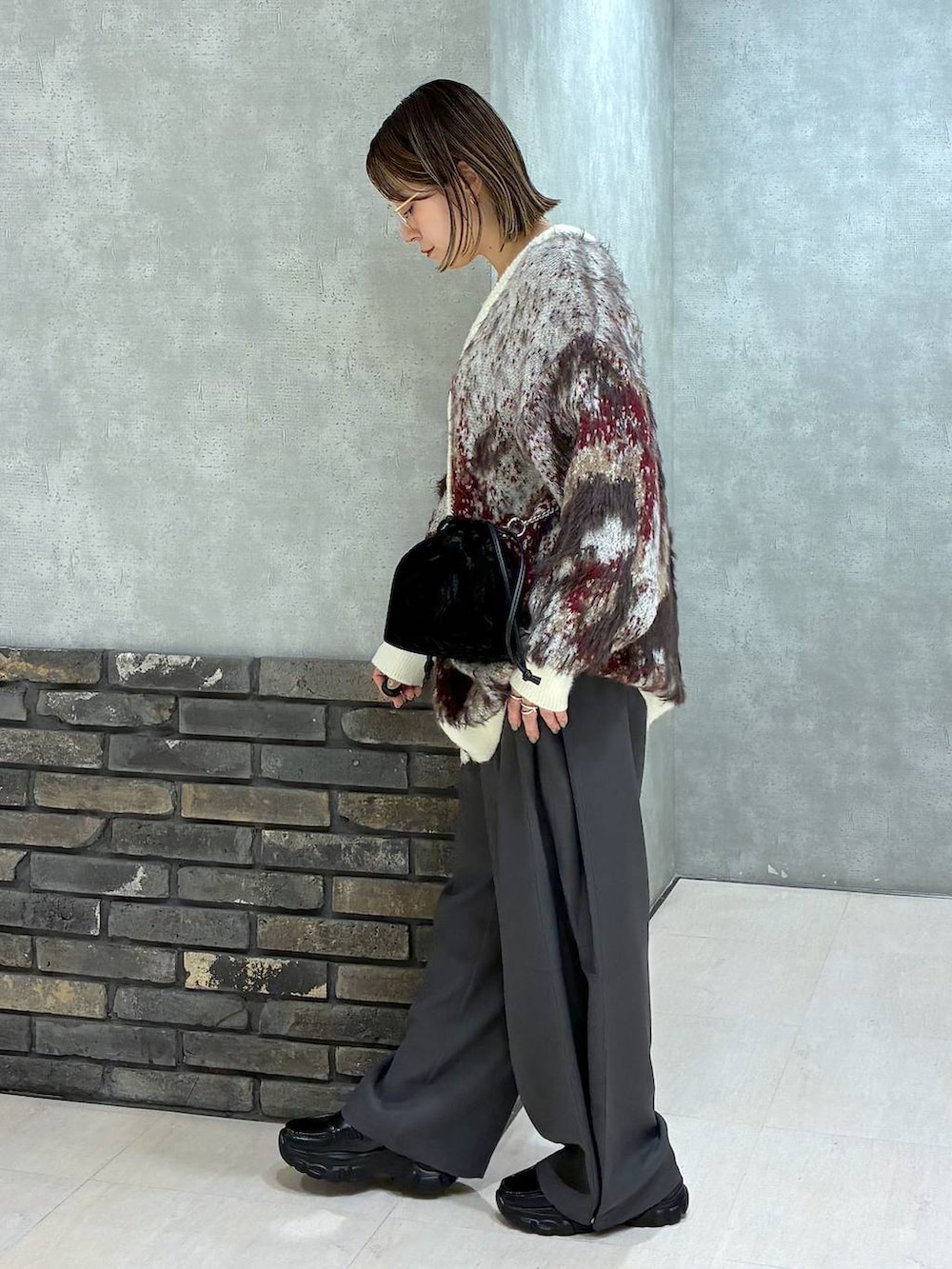 ホワイト系のTシャツ/カットソー、ホワイト系のカーディガン/ボレロ、グレー系のスラックスを着用したレディースの秋コーディネートの5枚目の写真