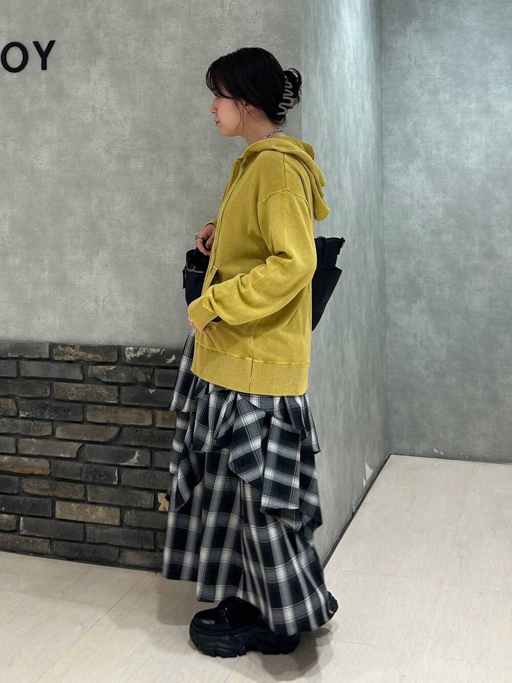 ブラック系のブーツ、ブラック系のキャミソール、ブラック系のボストンバッグを着用したレディースの秋コーディネートの5枚目の写真