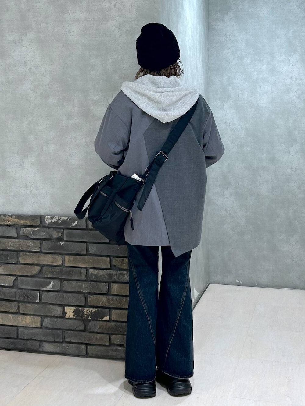 グレー系のスニーカー、ブルー系のデニムパンツ、グレー系のテーラードジャケットを着用したレディースの秋コーディネートの5枚目の写真