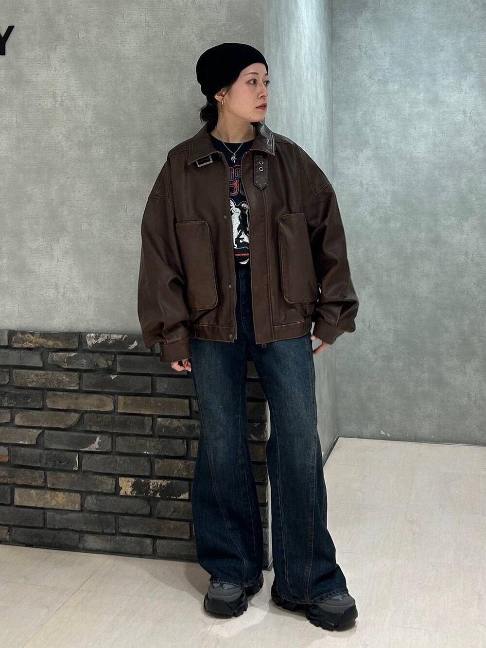 グレー系のスニーカー、ブルー系のデニムパンツ、ブラック系のTシャツ/カットソーを着用したレディースの秋コーディネートの7枚目の写真