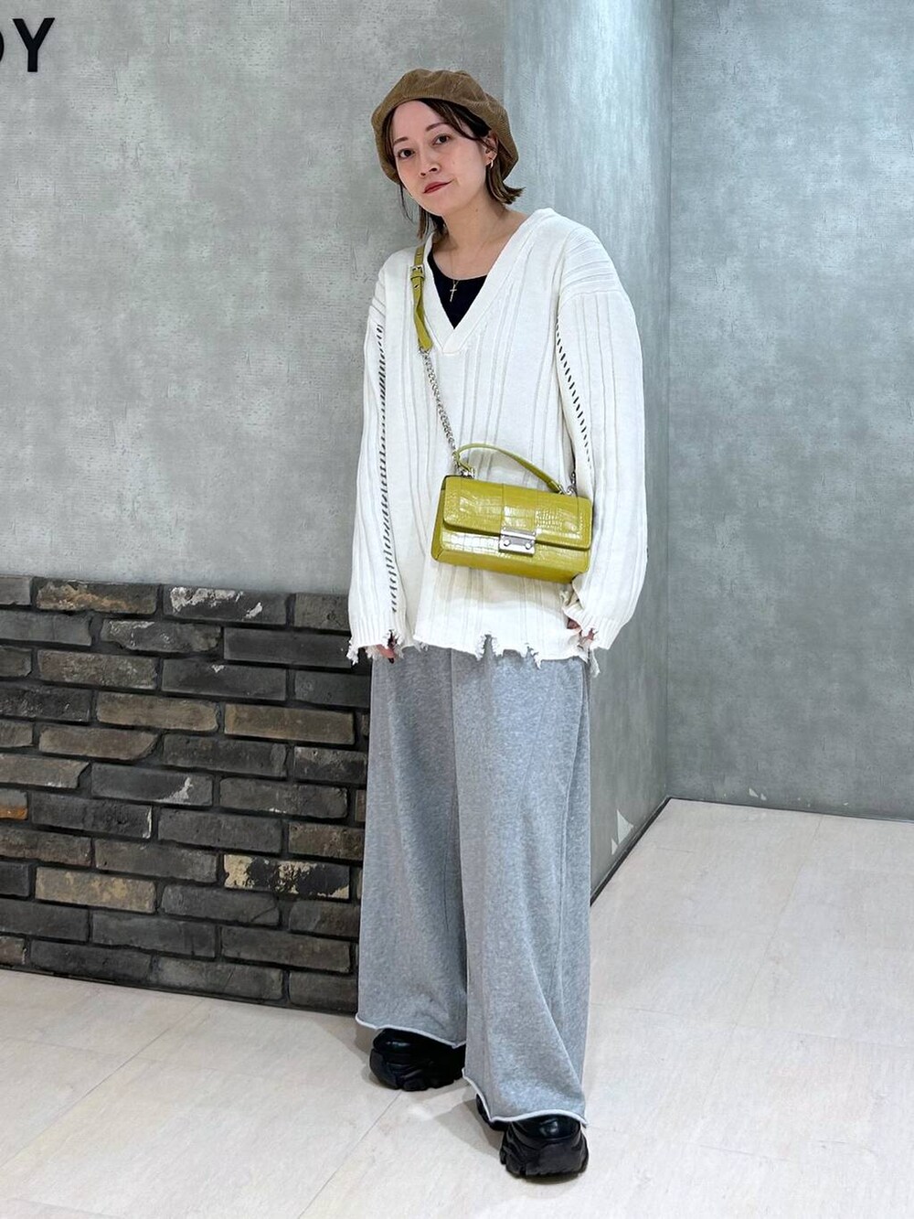 ブラック系のスニーカー、グレー系のスウェットパンツ、イエロー系のハンドバッグを着用したレディースの秋コーディネートの2枚目の写真