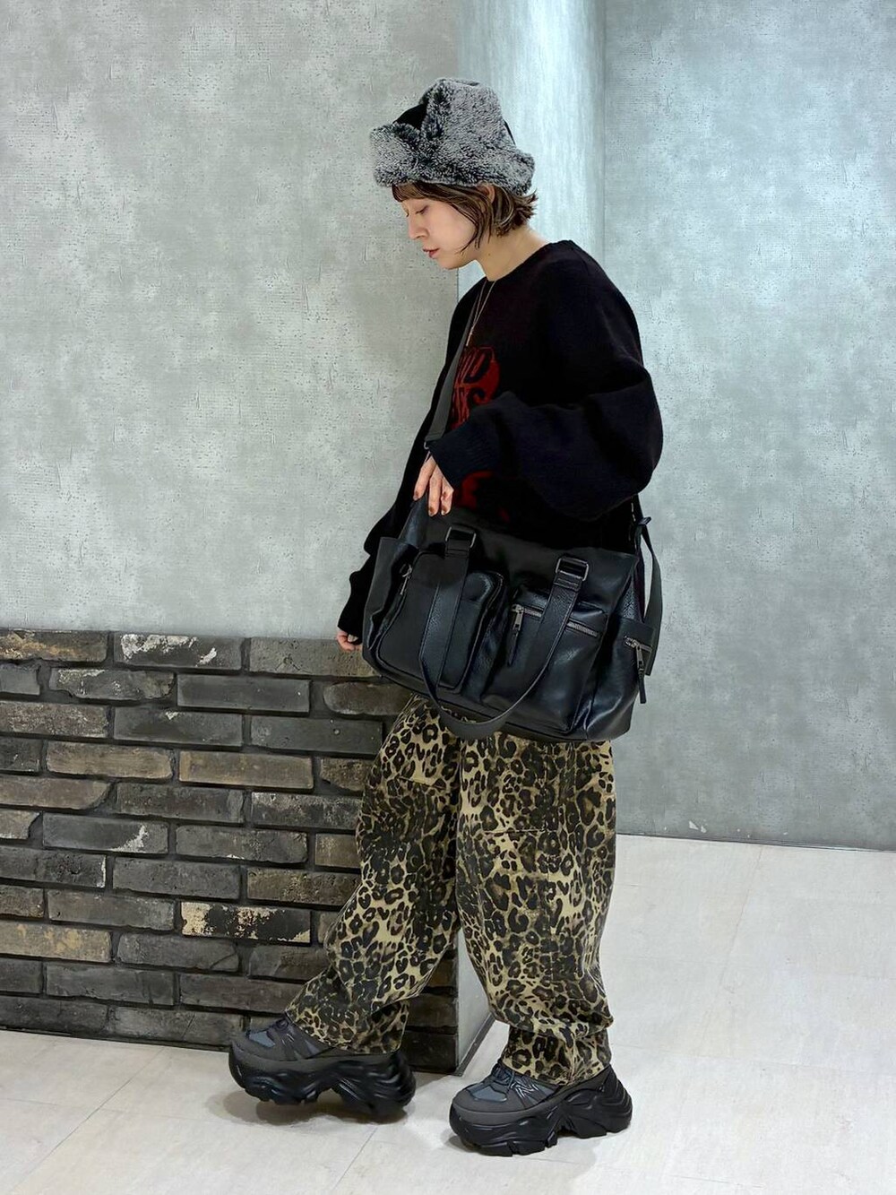 グレー系のスニーカー、ブラック系のボストンバッグ、ブラック系のニット/セーターを着用したレディースの冬コーディネートの6枚目の写真